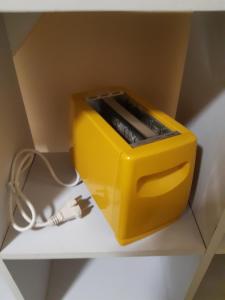 eine gelbe Kiste auf einem Regal in der Unterkunft Tindara's House in Francavilla di Sicilia