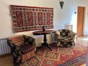 une chambre avec deux chaises, une table et un tapis dans l'établissement Hotel Mirhav, à Goris