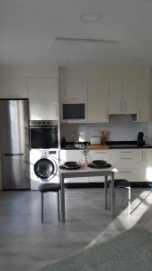 a white kitchen with a table and a refrigerator at Apartamentos SARABIA LOFT in Ourense +14 photos