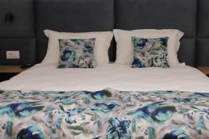 a bed with two pillows and a blanket on it at Casa din livada in Dragomireşti