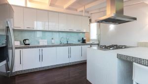 a white kitchen with white cabinets and a sink at Italianway Comfort - Torino 57 B in Milan