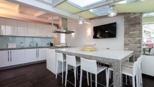 a kitchen with white cabinets and a large island with stools at Italianway Comfort - Torino 57 B in Milan