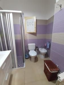 a purple bathroom with a toilet and a sink at Tindara's House in Francavilla di Sicilia +16 photos