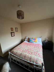 a bedroom with a bed with a colorful comforter at The Shambles by Spires Accommodation A Boho styled place to stay just 3 miles from Birches Valley visitors Centre Cannock Chase in Rugeley