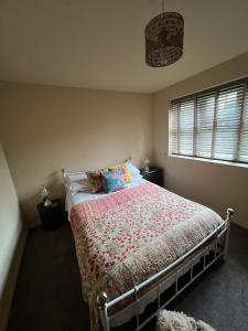 1 dormitorio con 1 cama con una manta colorida en The Shambles by Spires Accommodation A Boho styled place to stay just 3 miles from Birches Valley visitors Centre Cannock Chase, en Rugeley