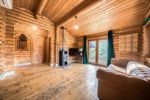 a living room in a log cabin with a couch at Kingfisher Lodge and mooring on the River Ouse in Renhold