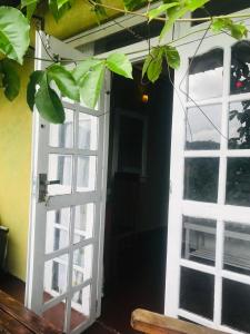 uma porta aberta com uma janela num quarto em Minthu Homestay em Ella