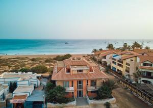a group of houses in front of the beach at Corallo Beachfront Penthouse by Bobbywashere in Santa Maria