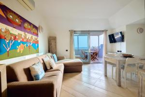 a living room with a couch and a dining room at Corallo Beachfront Penthouse by Bobbywashere in Santa Maria