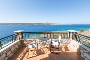 balcón con mesa, sillas y vistas al océano en Villa Forteza, en Kalami