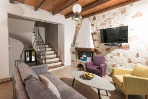 sala de estar con sofá, sillas y TV en Villa Forteza, en Kalami