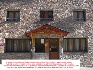 a brick building with a door with a bar on it at Apartaments Vilaró in Llorts