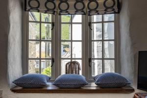 a window seat with pillows in front of a window at Sea Horses in Port Isaac +17 photos