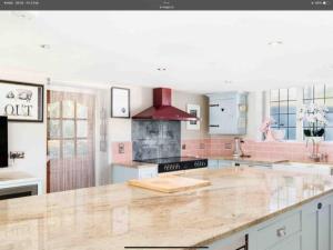 uma cozinha com um balcão de mármore e um capô vermelho em Piglet Lodge em Pebworth