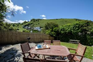 a wooden table and chairs in a yard at Sea Horses in Port Isaac