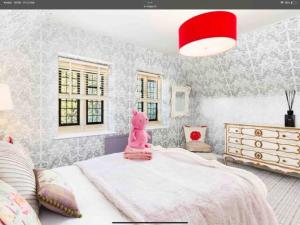 um quarto com um elefante rosa sentado numa cama em Piglet Lodge em Pebworth