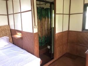 Cette chambre comprend un lit et une porte menant à une chambre. dans l'établissement Sobral Rice Terraces View, 