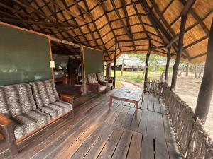 une terrasse couverte avec des canapés et une table sur une terrasse en bois dans l'établissement Sukulu Reserve, à Livingstone