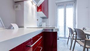 a kitchen with red cabinets and a table and chairs at Italianway Comfort - Merlo 1 D in Milan