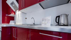 a kitchen with red cabinets and a sink at Italianway Comfort - Merlo 1 D in Milan +12 photos