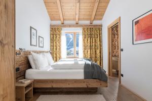 um quarto com uma cama e uma janela em Cësa Marmolada 1318 em Ortisei
