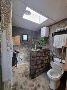 a stone bathroom with a toilet and a sink at Khaya Nzuri 