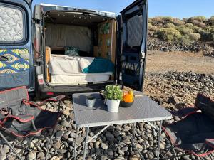a table with a bed in the back of a van at The Blue Whale in Los Abrigos