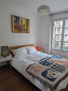 Un dormitorio con una cama con una manta. en Maison Luxe avec Jardin, 5 Chambres, Home Cinéma - Métro 1 en Vincennes