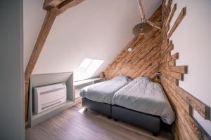 een slaapkamer met een bed met een houten muur bij Salty Vibes in Middelkerke