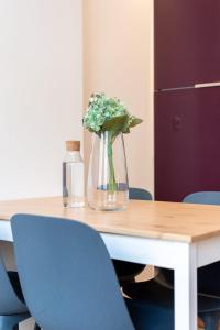 a table with a vase of flowers and a bottle at Lille Centre - Nice ap. 4pers in Lille