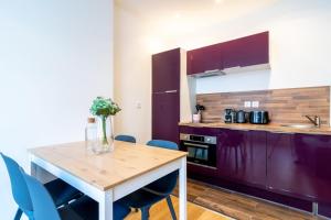 eine Küche mit einem Holztisch und blauen Stühlen in der Unterkunft Lille Centre - Nice ap. 4pers in Lille