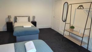 a bedroom with two beds and a mirror at Alexander Apartments Westoe in South Shields