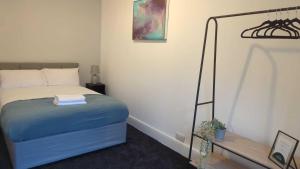 una camera con un letto e una coperta blu di Alexander Apartments Westoe a South Shields