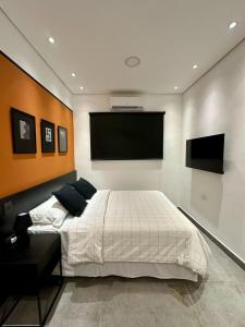 a bedroom with a bed and a flat screen tv at Lola’s home in Asunción