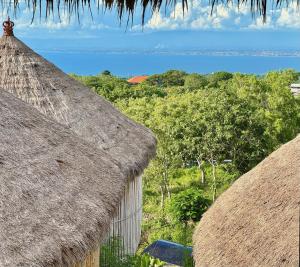 two thatch huts with a view of the ocean at Hillstone Luxury Village in Ungasan