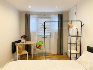 a bedroom with a bed and a desk and a table at CozyTomari in London