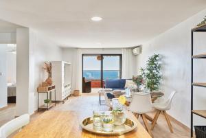 ein Esszimmer und ein Wohnzimmer mit Tisch und Stühlen in der Unterkunft Sunrise & Sunset Unique Experience Sea Views Parking Pool Mijas Costa & Fuengirola in Mijas Costa