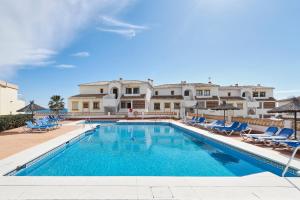 ein Swimmingpool mit Liegestühlen und ein Gebäude in der Unterkunft Sunrise & Sunset Unique Experience Sea Views Parking Pool Mijas Costa & Fuengirola in Mijas Costa