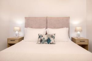 ein Schlafzimmer mit einem weißen Bett mit zwei Lampen in der Unterkunft Villa Seva Sea View in Skinária