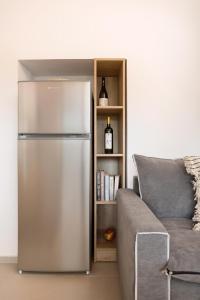 a stainless steel refrigerator in a living room next to a couch at Villa Seva Sea View - Perfect for Romantic Getaways with Pool and Sunrise & Sea Views By Villa Mana Gers in Skinária