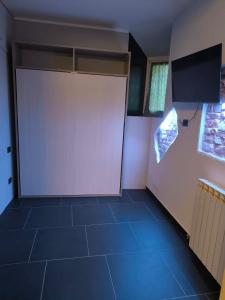 PM 410 Via Delle Forze Armate Guest House في ميلانو: باب أبيض كبير في غرفة ذات بلاط أزرق