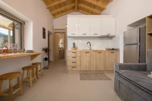 eine Küche und ein Wohnzimmer mit weißen Schränken in der Unterkunft Villa Seva Sea View in Skinária