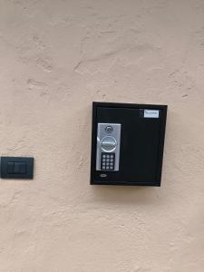 PM 410 Via Delle Forze Armate Guest House في ميلانو: يوجد هاتف ملتصق بجهة الجدار