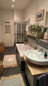 ein Badezimmer mit einer Badewanne, einem Waschbecken und einer Badewanne in der Unterkunft Gemütliche Wohnung in Gohlis in Leipzig