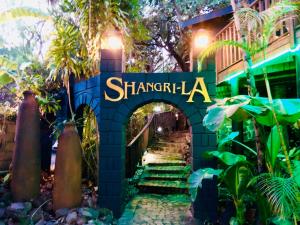 um sinal que diz shangla em frente a um edifício em Shangri-La Country Hotel & Spa em Modimolle