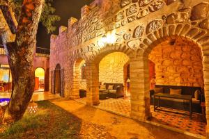 a building with a stone wall with couches and a tree at DAR ETTO Riad & Spa in Essaouira