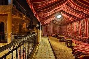 a room with chairs and tables and a curtain at DAR ETTO Riad & Spa in Essaouira