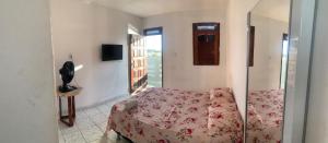 1 dormitorio con 1 cama en una habitación con ventana en Suítes Mar Azul en Aracaju