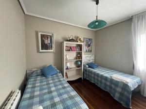- une chambre avec 2 lits et une étagère dans l'établissement Habitación Aeropuerto Loiu, à Loiu