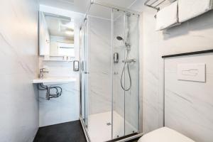 uma casa de banho com um chuveiro, um WC e um lavatório. em Hotel Hulst em Hulst